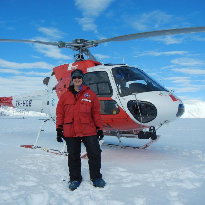 Samantha Hansen standing in front of an A-star helicopter in Antarctica